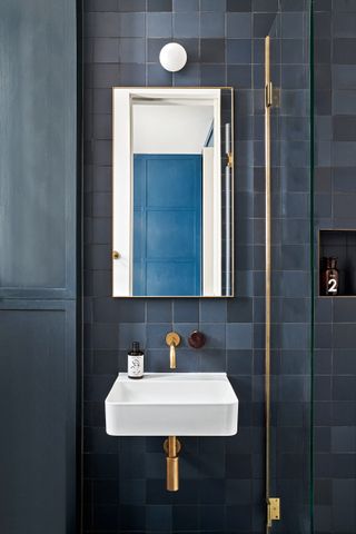 Small dark blue tiled bathroom