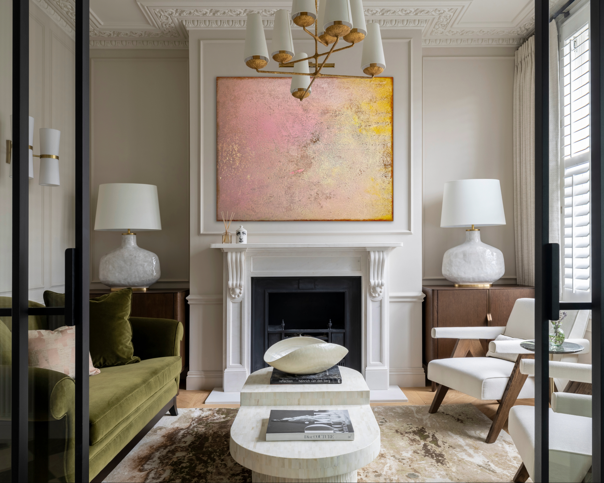 A living space with neutral walls offset against colourful artwork over the fireplace.