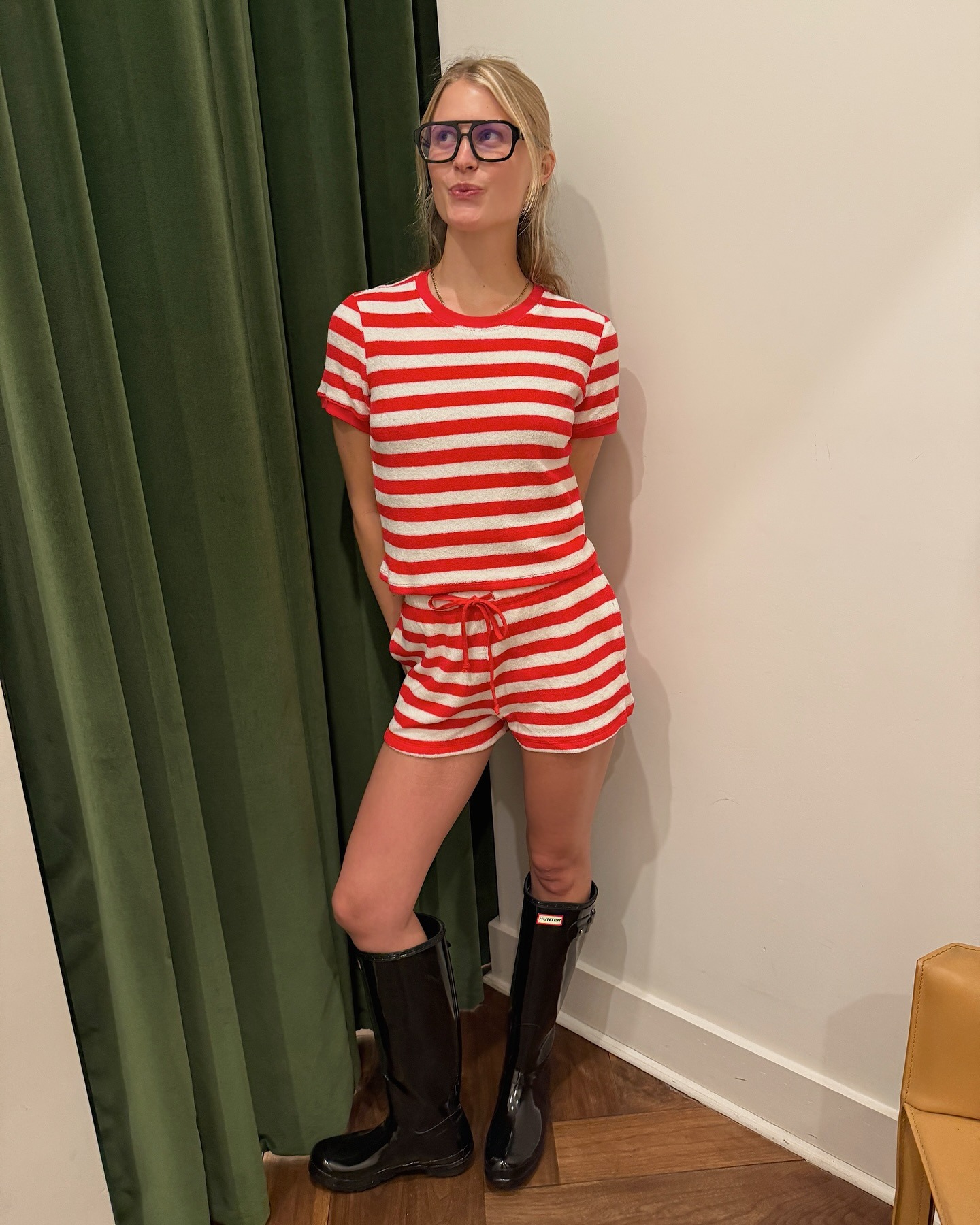 New York based influencer Laure wears a white and red striped set with black Hunter rain boots.