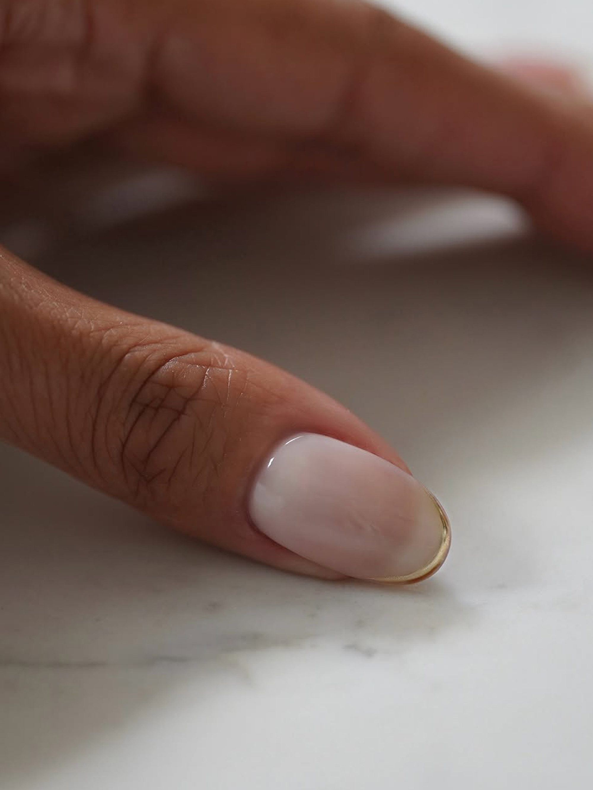 A short manicure with gold tips by Iram Shelton