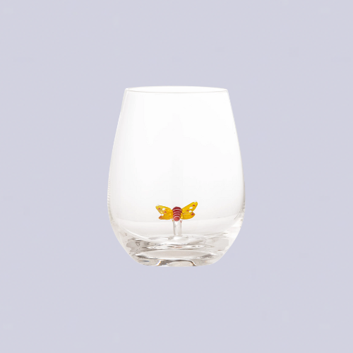 A round glass tumbler with a butterfly figurine inside