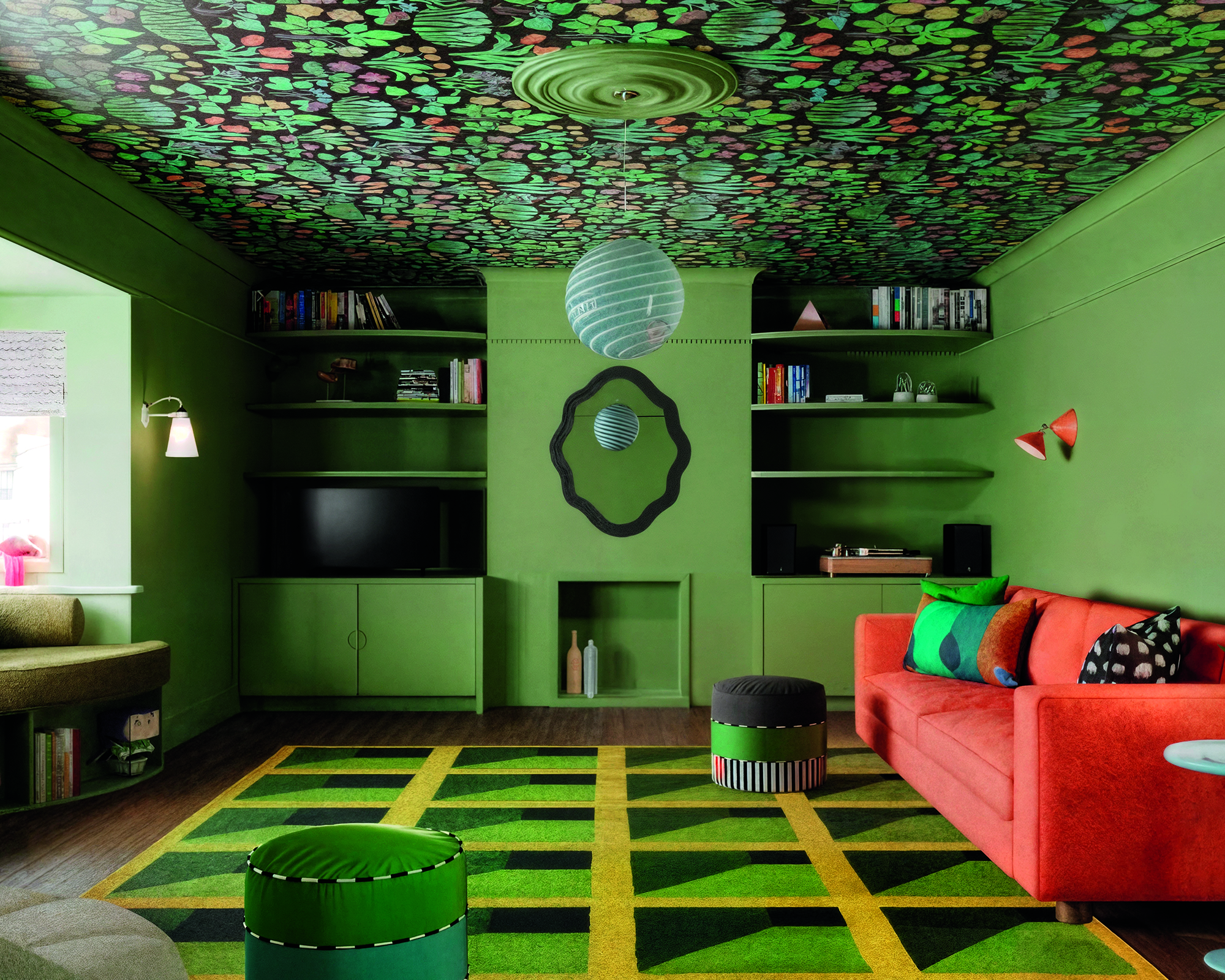 green living room with graphic rug on the floor and floral wallpaper on the ceiling
