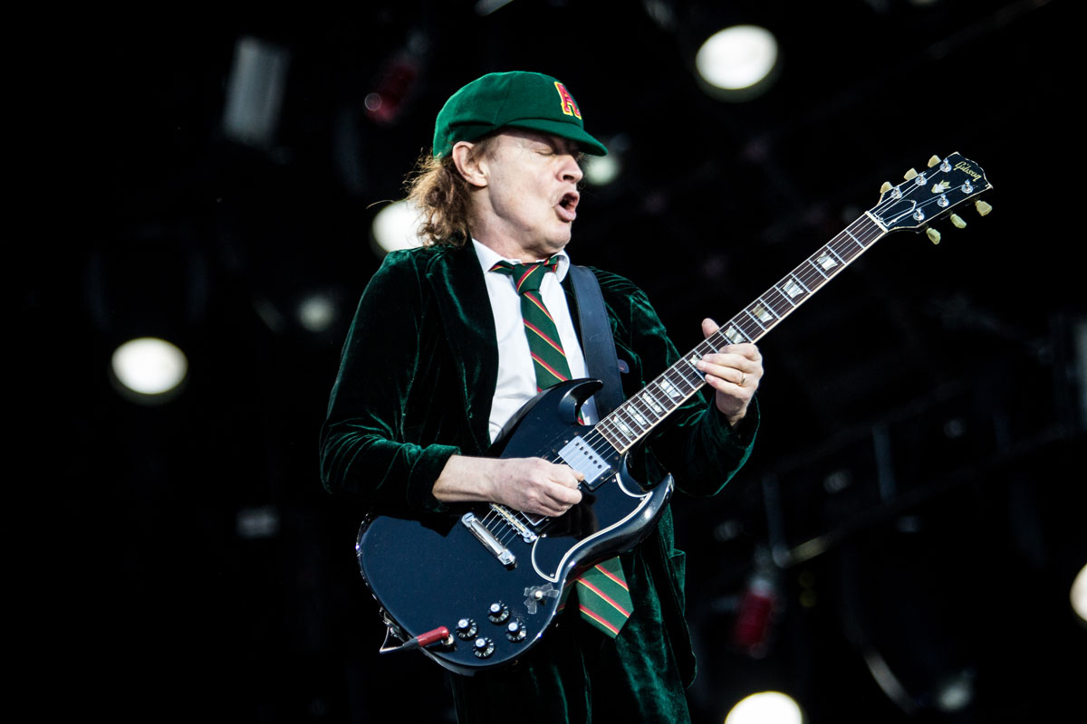 Янг фото. Гитарист AC DC Ангус. Гитарист AC DC. Angus young с гитарой. Басист AC DC.