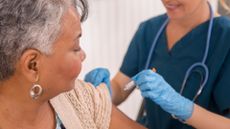 Nurse gives a vaccine to an older woman at a clinic