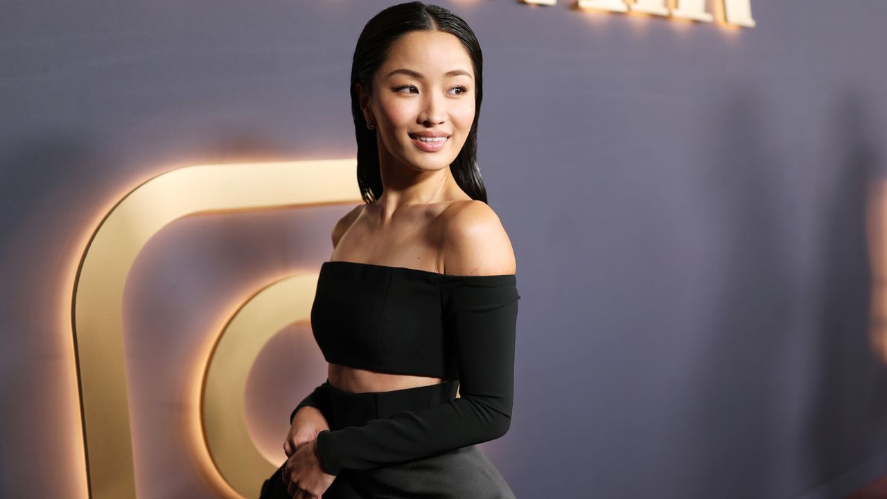 Anna Sawai attends a pre oscars party wearing an off the shoulder Carolina Herrera dress with a rosette skirt