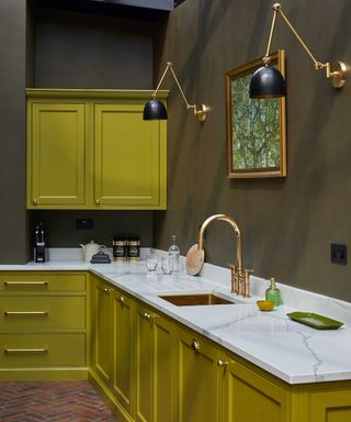 Citrine-coloured kitchen with white worktops and olive-coloured painted walls