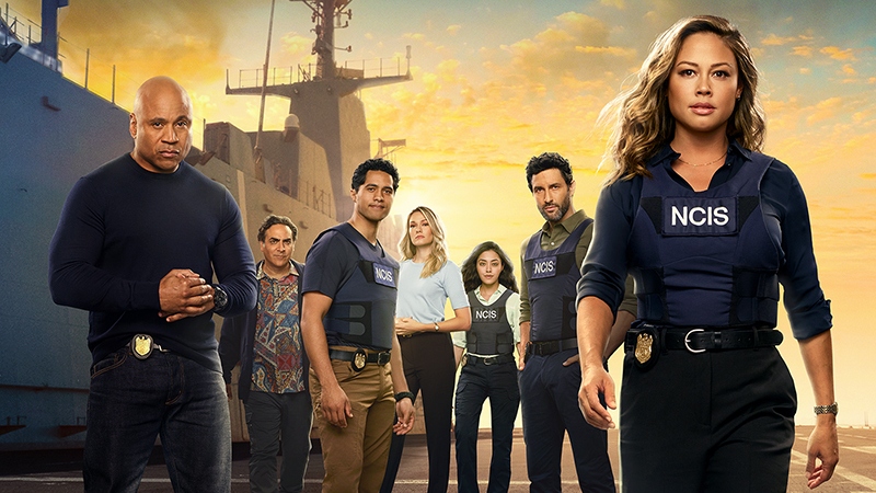 The cast of NCIS: Hawai'i standing in front of a navy ship.