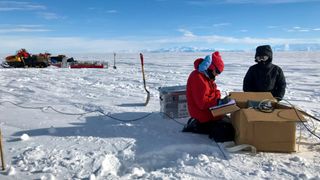 Author Chloe Gustafson and mountaineer Meghan Seifert installing a magnetotelluric station on the Whillans Ice Stream, West Antarctica.
