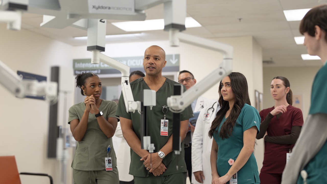 Turk and other Sacred Heart employees looking at the hospital's new surgical robot