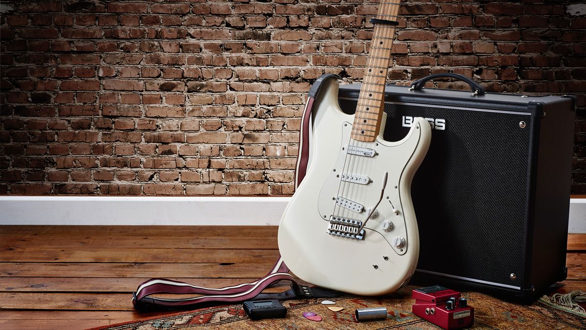 Photo of a guitar, amp and pedals in a home