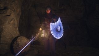 A warrior Arisen walking through a dark cave in Dragon's Dogma 2.