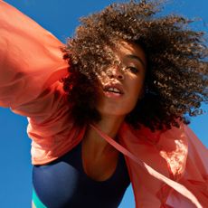 Directly below shot of female athlete with curly hair against clear sky