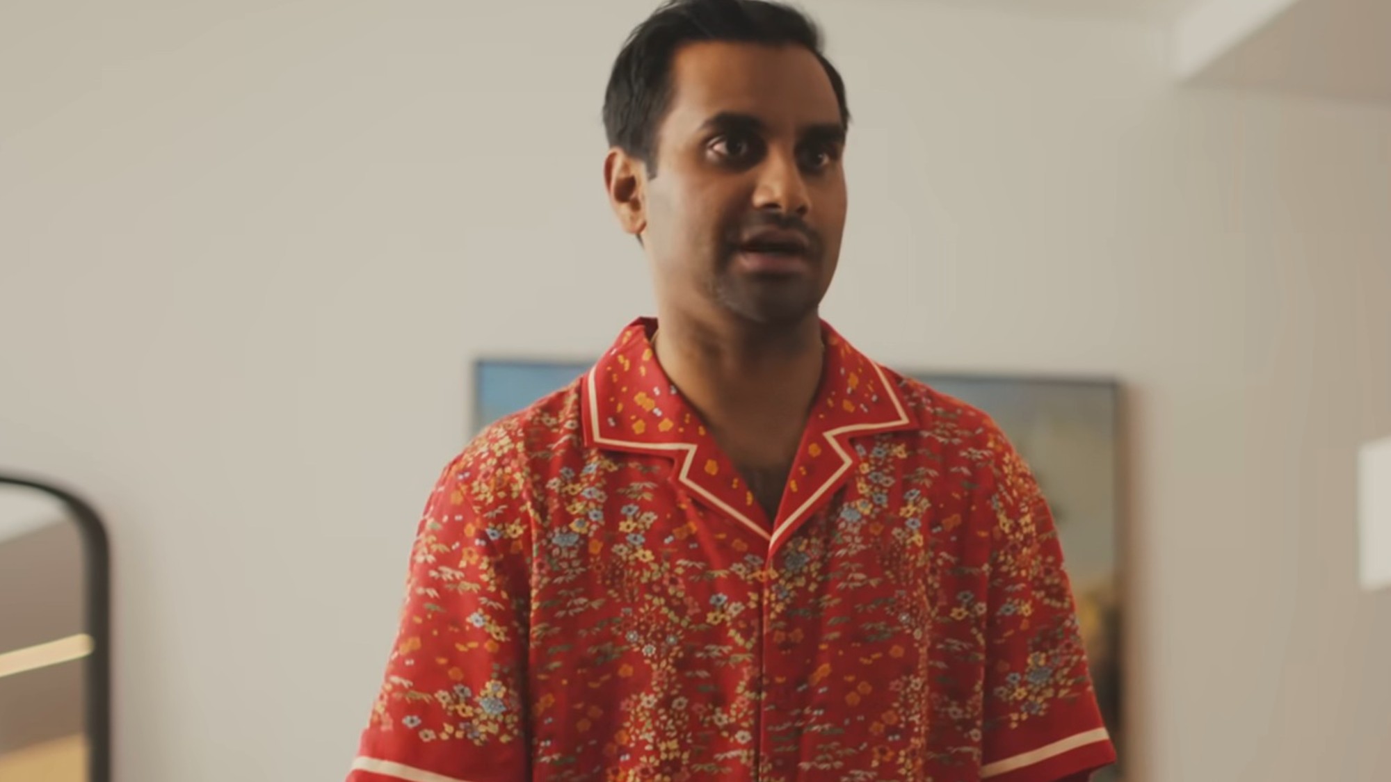 Aziz Ansari wearing a red shirt in Good Fortune