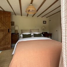 rustic bedroom with peach blanket on the bed