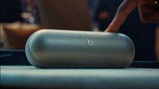 Capture d'écran d'un teaser posté par Beats by Dre sur X, montrant une main appuyant sur le bouton supérieur d'un haut-parleur Beats.