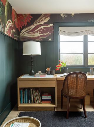 Home office with grey paneling, floral wallpaper and wood desk