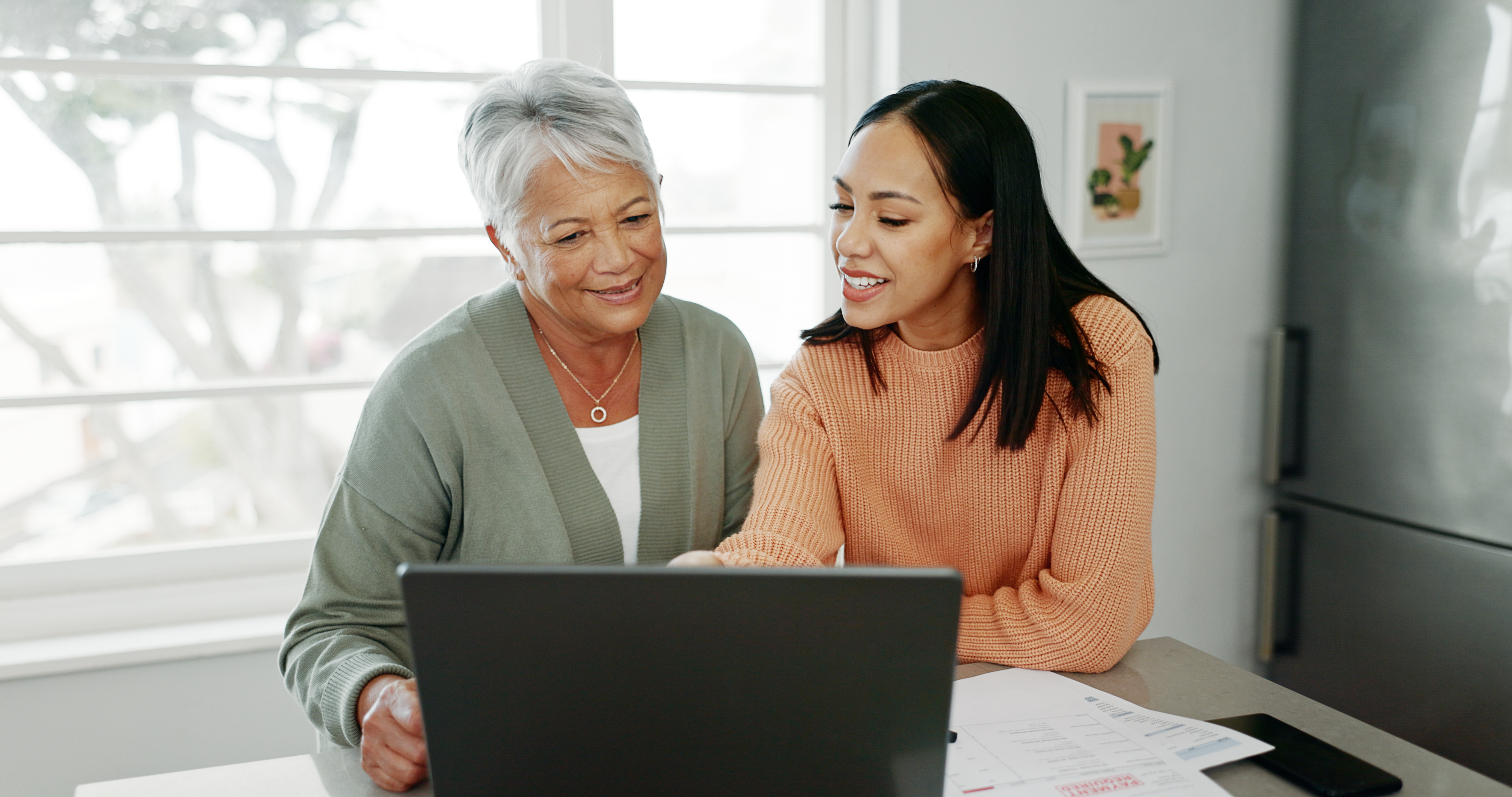 Kitchen, mother and woman with laptop for finance, track expenses and success for budget goals. Discussion, senior mom and daughter with tax review for retirement, handle savings and mortgage at home