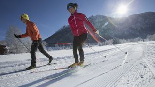 A man and woman cross country skiing