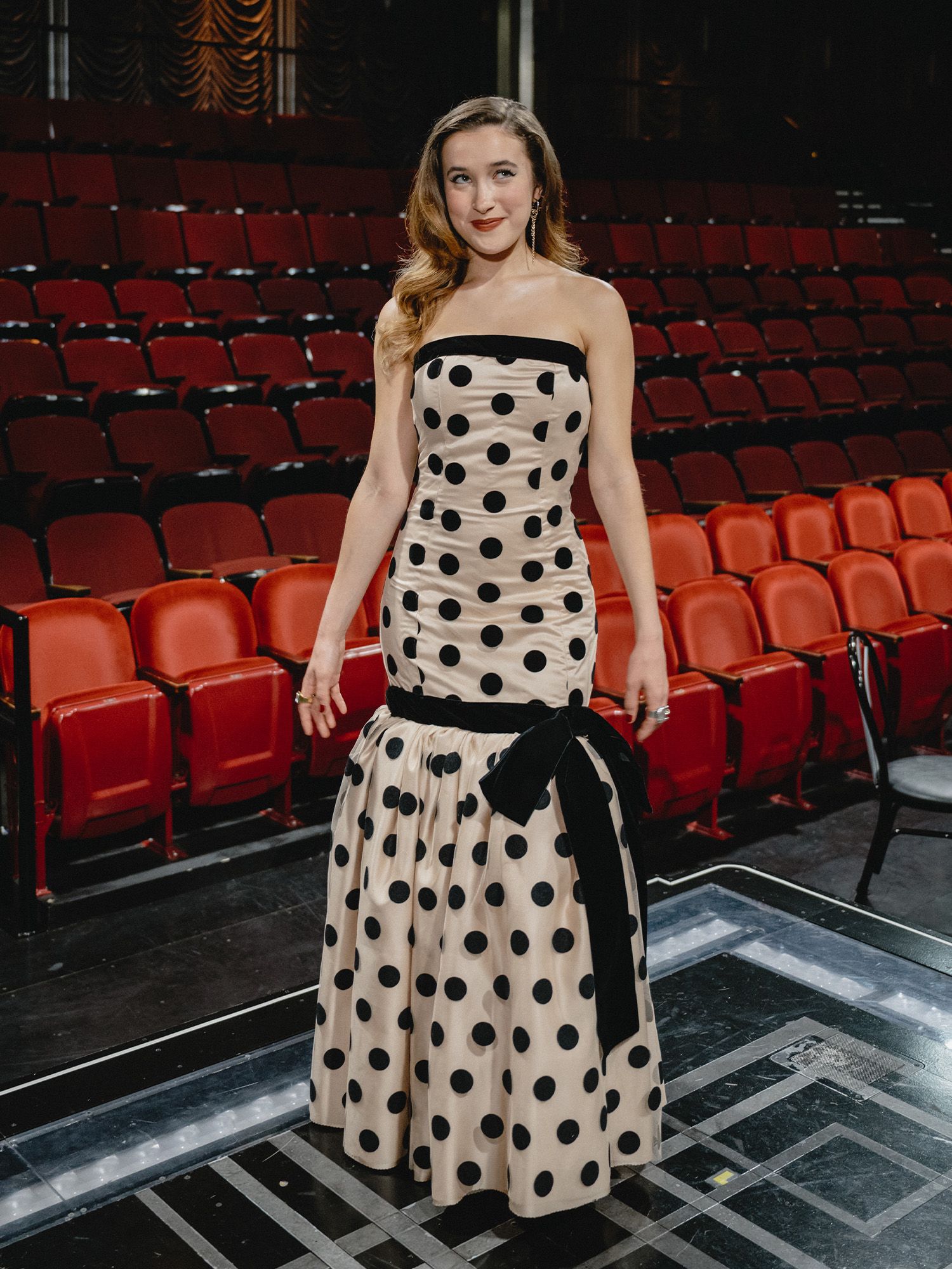 Gracie Lawrence poses for a photo before heading to the 2025 Tony Awards. She is wearing a strapless polka dot gown.