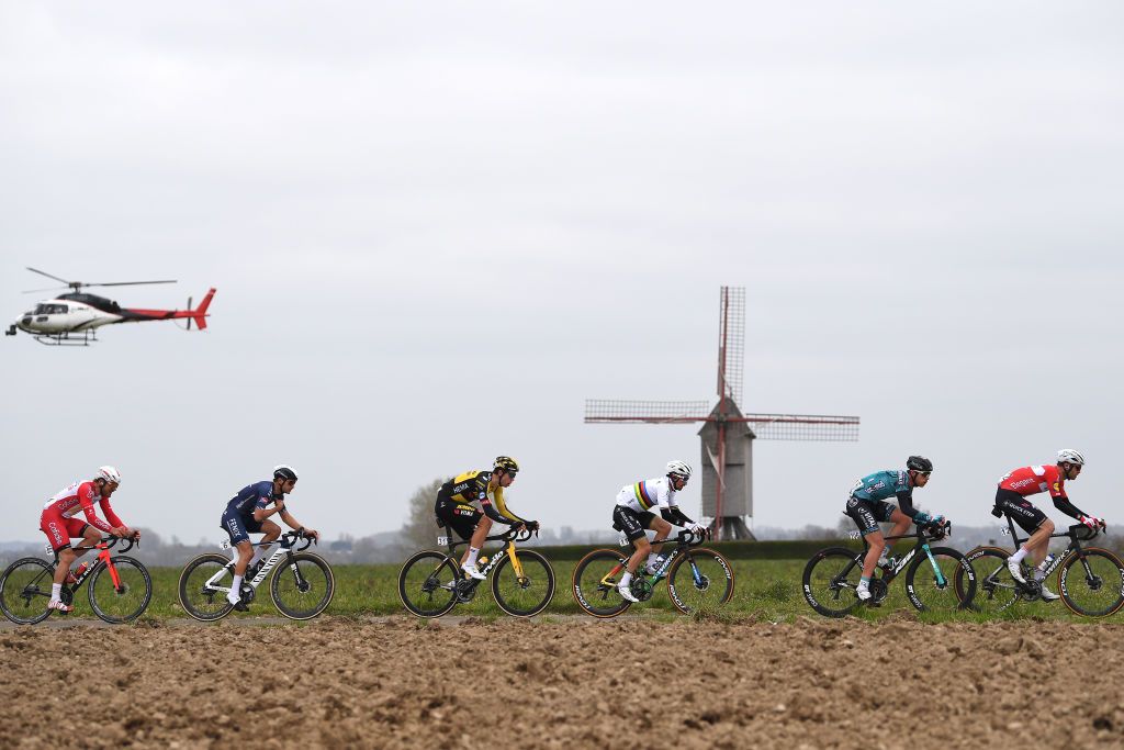 OUDENAARDE BELGIUM APRIL 04 Jean Pierre Drucker of Luxembourg and Team Cofidis Gianni Vermeersch of Belgium and Team AlpecinFenix Wout Van Aert of Belgium and Team Jumbo Visma Jeremy Lecroq of France and Team BB Hotels PB KTM Kasper Asgreen of Denmark and Team Deceuninck QuickStep The Peloton passing through Molenberg sector during the 105th Ronde van Vlaanderen Tour of Flanders 2021 Mens Elite a 2515km race from Antwerp to Oudenaarde Windmill Helicopter Landscape RVV21 rondevanvlaanderen tourofflanders on April 04 2021 in Oudenaarde Belgium Photo by Tim de WaeleGetty Images