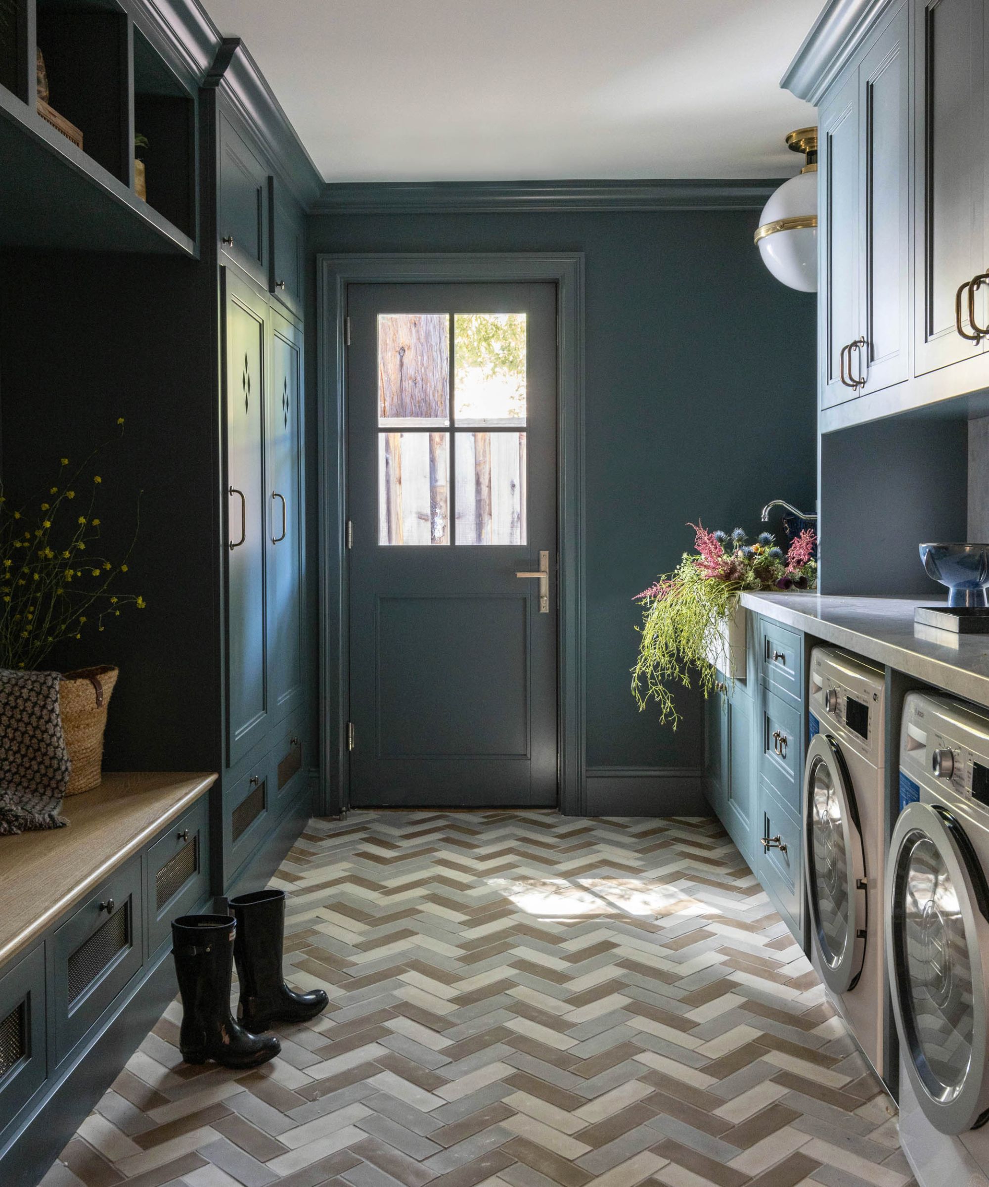 Blue laundry room and mudroom with a herringbone porcelain brick floor