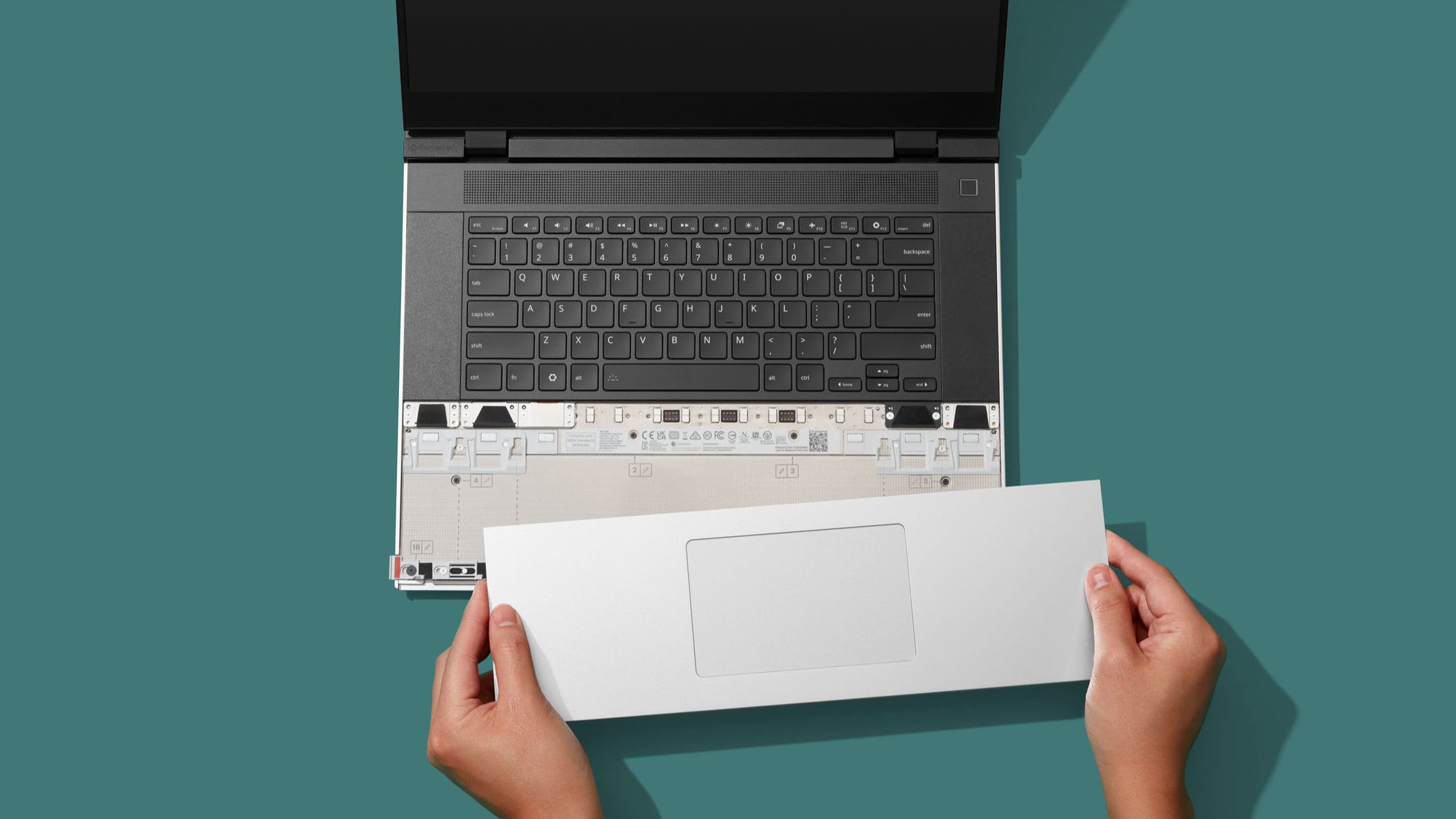 شخصی که پد لمسی جدید Framework را روی لپ تاپ 16 نصب می کند