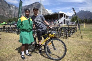 Mark Cavendish poses with one of the school children
