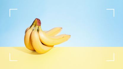 A bunch of fresh bananas on yellow and blue background to symbolise the benefits of magnesium and one of the foods rich in the mineral