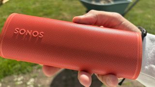 Sonos Roam 2 wireless speaker held in hand in garden