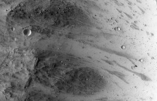 NASA's Mars Reconnaissance Orbiter snapped this view, showing the the trail left by a rolling boulder that tumbled down the side of a slope, on July 3, 2014.