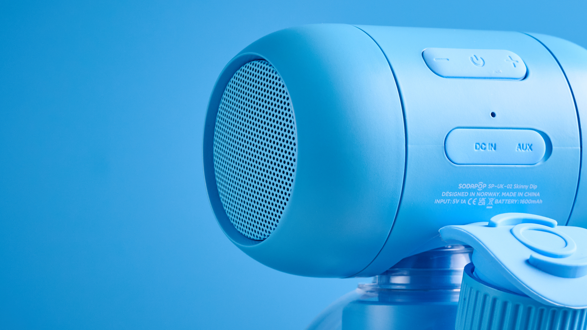 A blue Sodapop Bluetooth speaker that screws onto any regular-sized bottle
