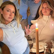 New York City style and beauty influencer Martine Lavelle wearing spring outfits featuring a blue Belle Ciel sleeveless top, Levi's jeans, studded Tory Burch flats, Gimaguas zipper sweater, large hoop earrings, lip liner, and bronzer.