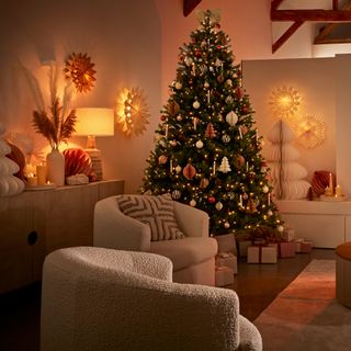 A living room with a Christmas tree decorated with paper ornaments