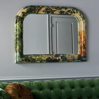 A semicircle mirror with green and yellow upholstery around the edge