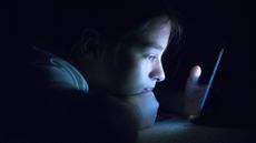 Teenager using their phone in bed late at night