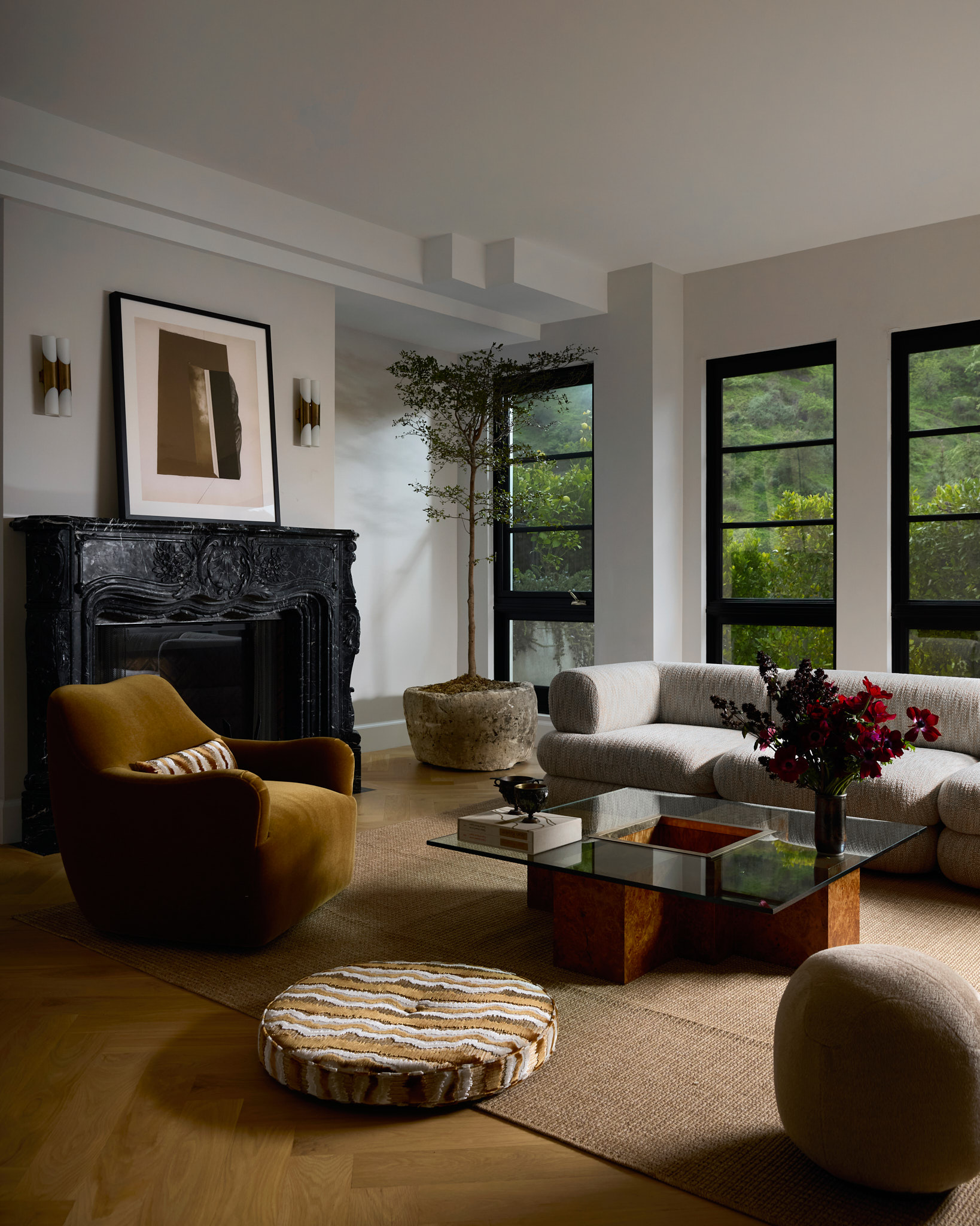 A living room featutring Nina Takesh Furniture, including an armchair, stool, coffee table, and sofa.