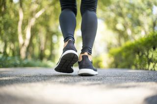 A close up of a woman's shoes walking along pavement