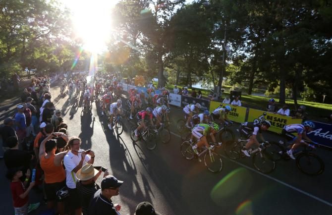 The sun sets behind the peloton