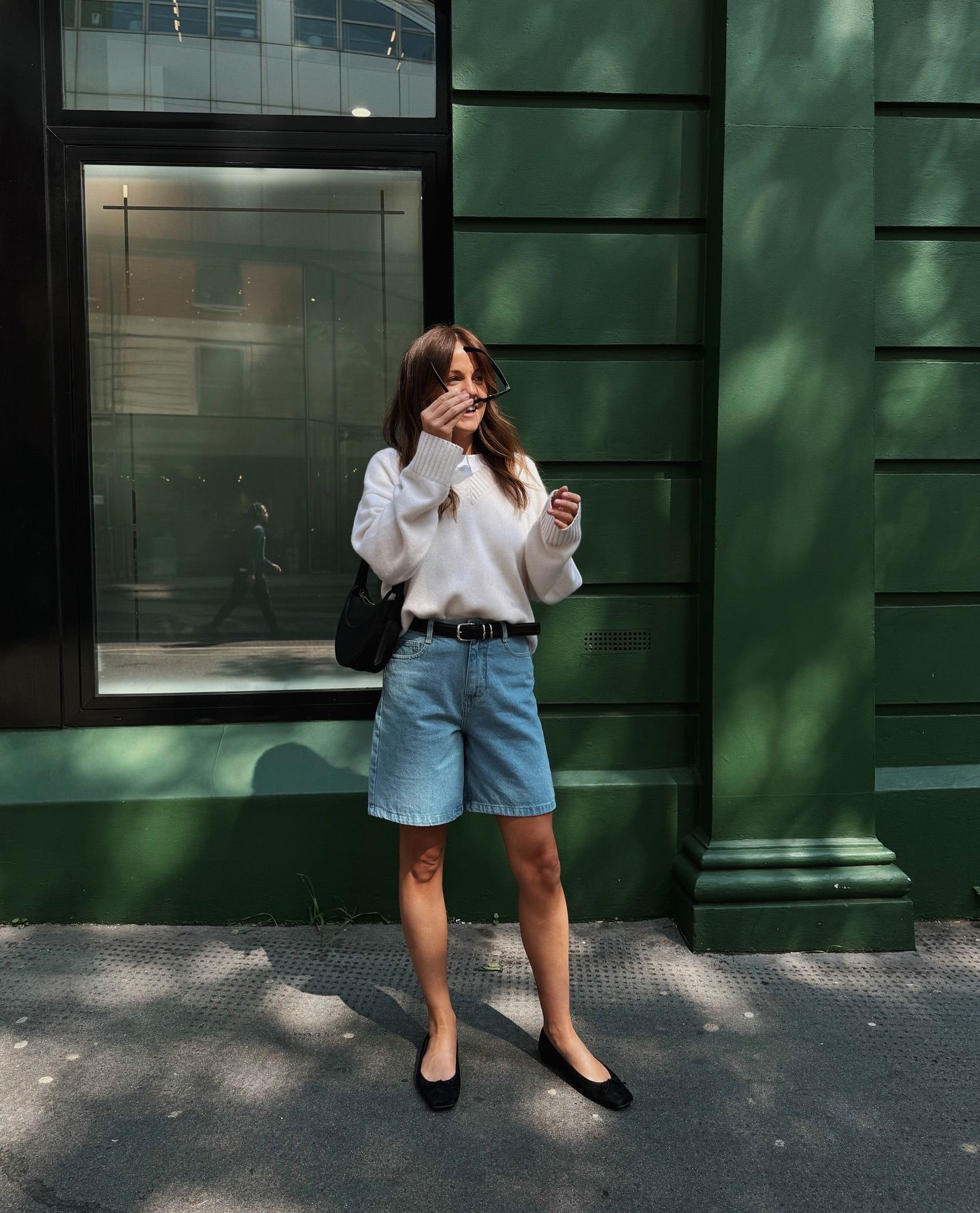 Woman wears jumper, denim shorts and ballet flats