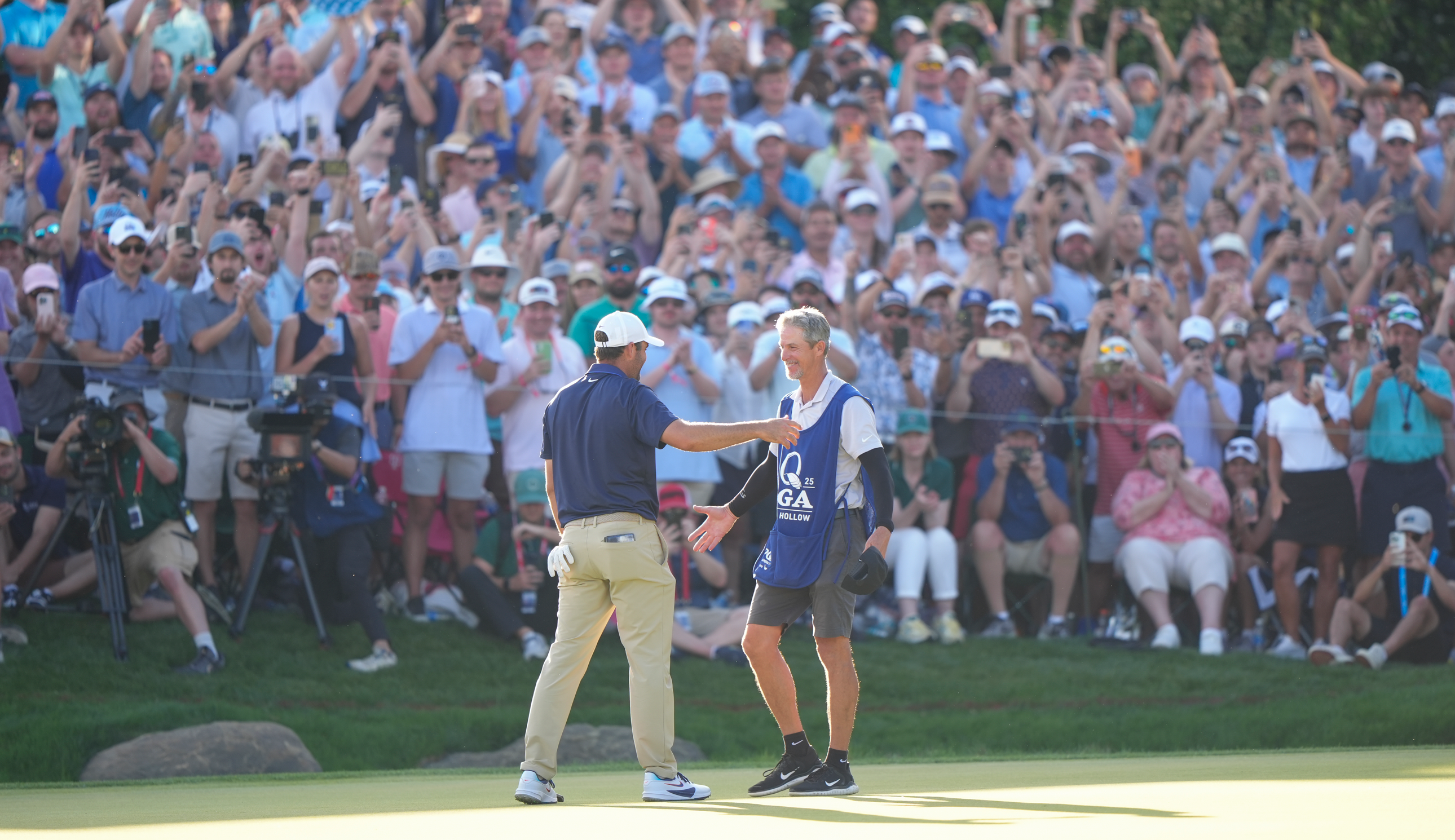 Scottie Scheffler and his caddie hug on the 18th green