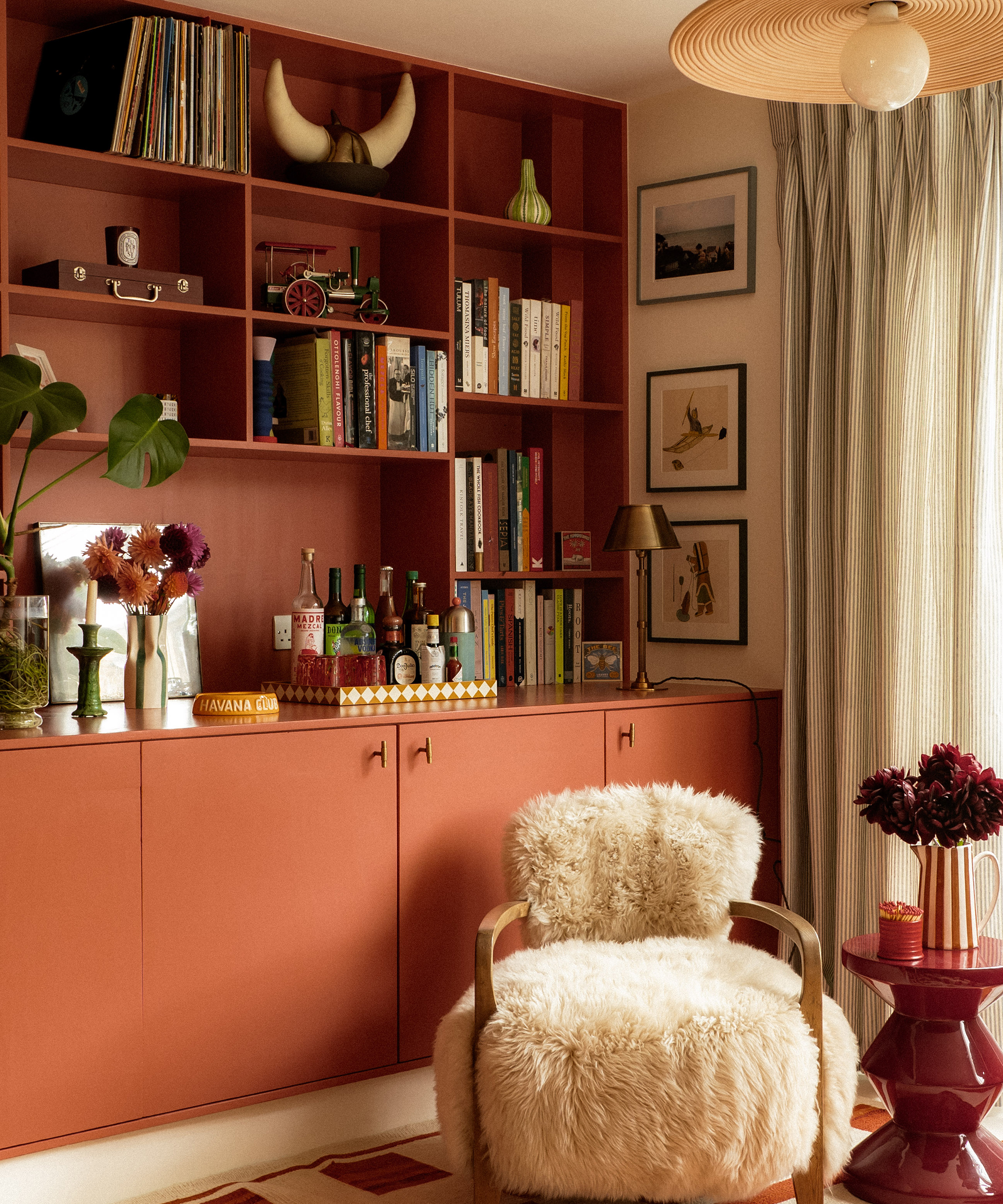 living room with terracotta joinery and white fluffy armchair