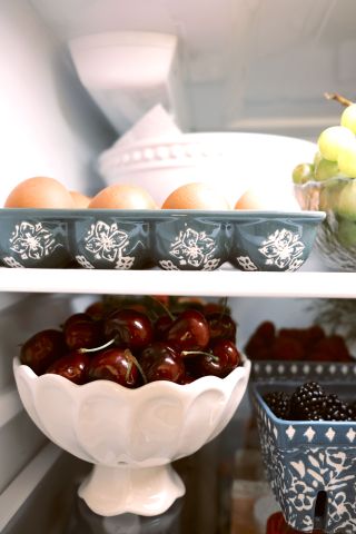 Eggs and cherries inside of a fridge