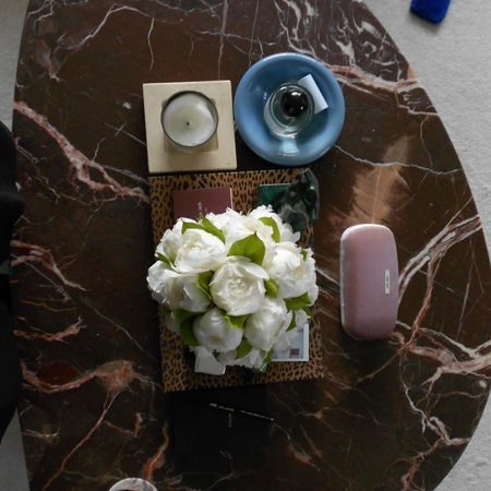 Photo of a perfume and candle on a coffee table