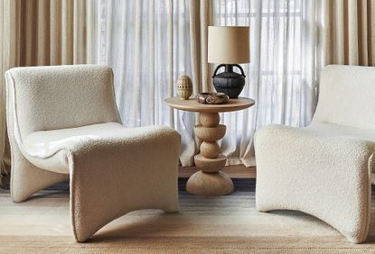 A classic modern living room with two contemporary sofa chairs and a wooden side table with a lamp