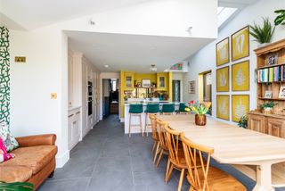 white and yellow kitchen with large wooden dining table