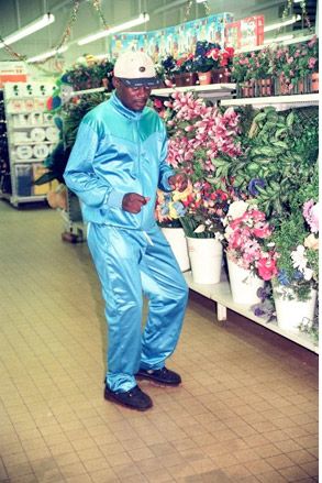 African male wearing shiny blue track suit in supermarket
