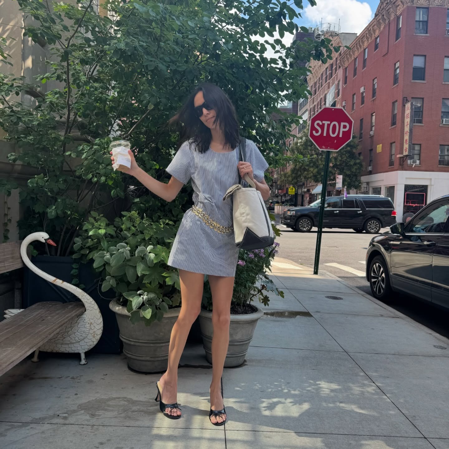 Alexa Chung wears heels mules with a blue and white cotton striped minidress.