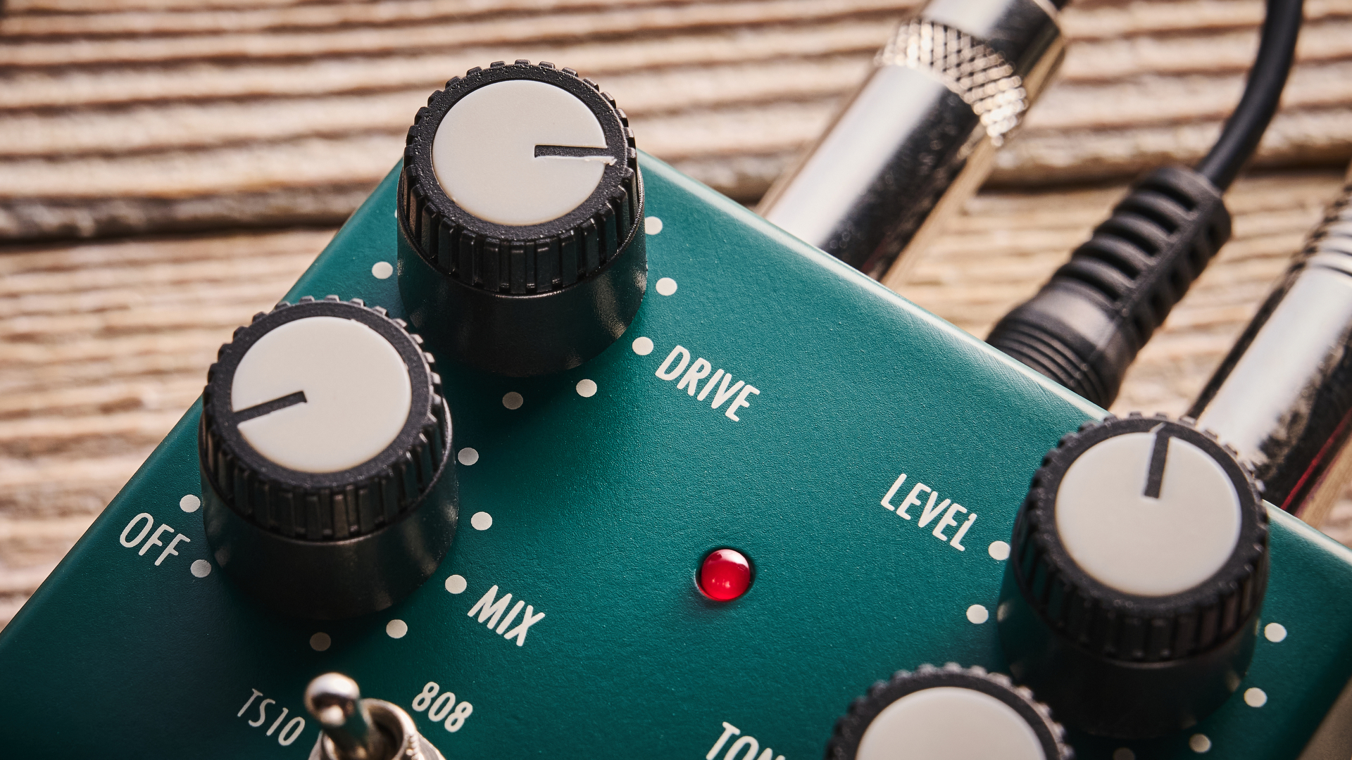 Warm Audio Tube Squealer green overdrive pedal shot on wood floorboards