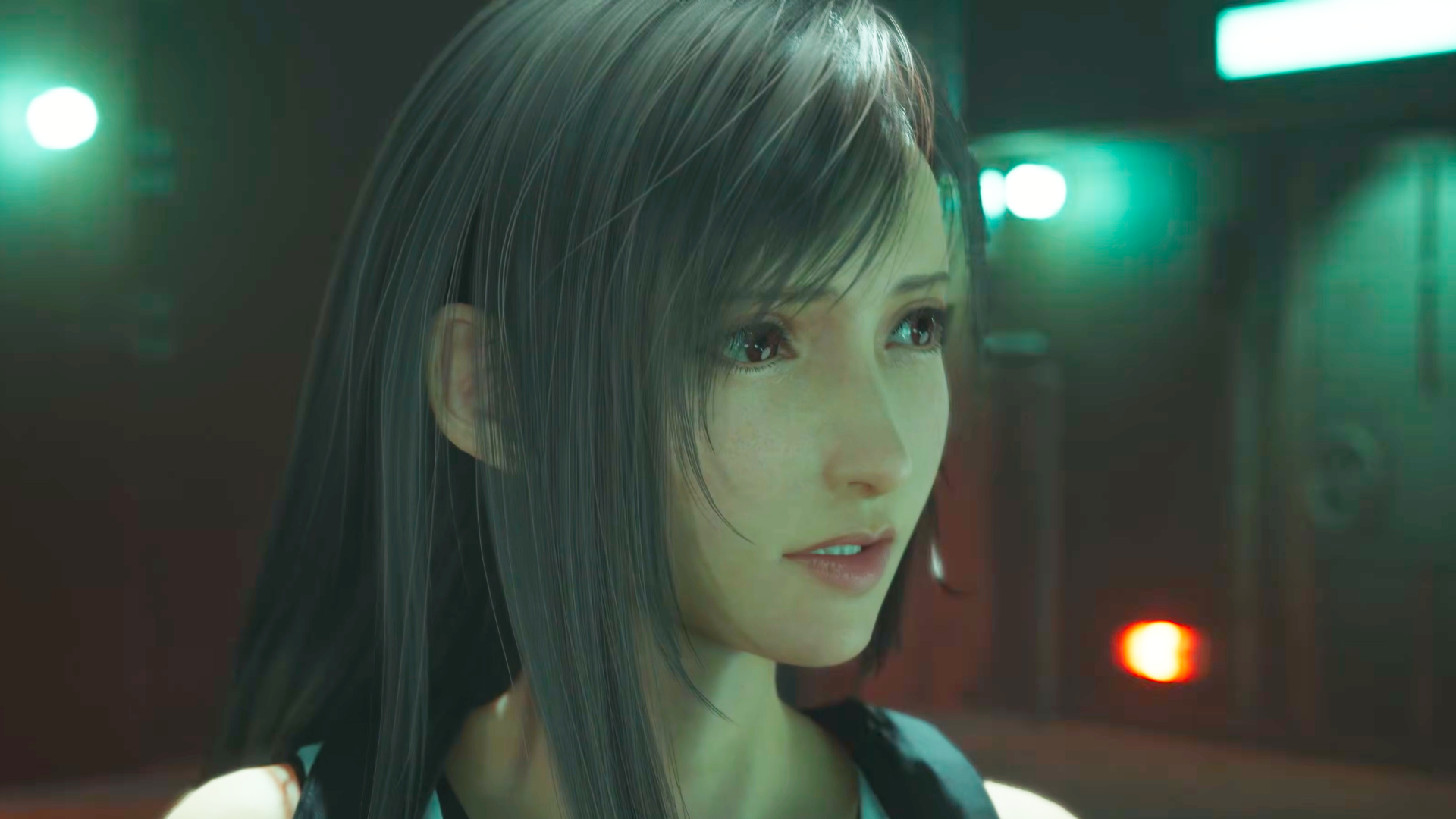 A screenshot of the Final Fantasy 7 Revelation trailer. Central character Tifa looks concerned while standing in a brightly lit facility.