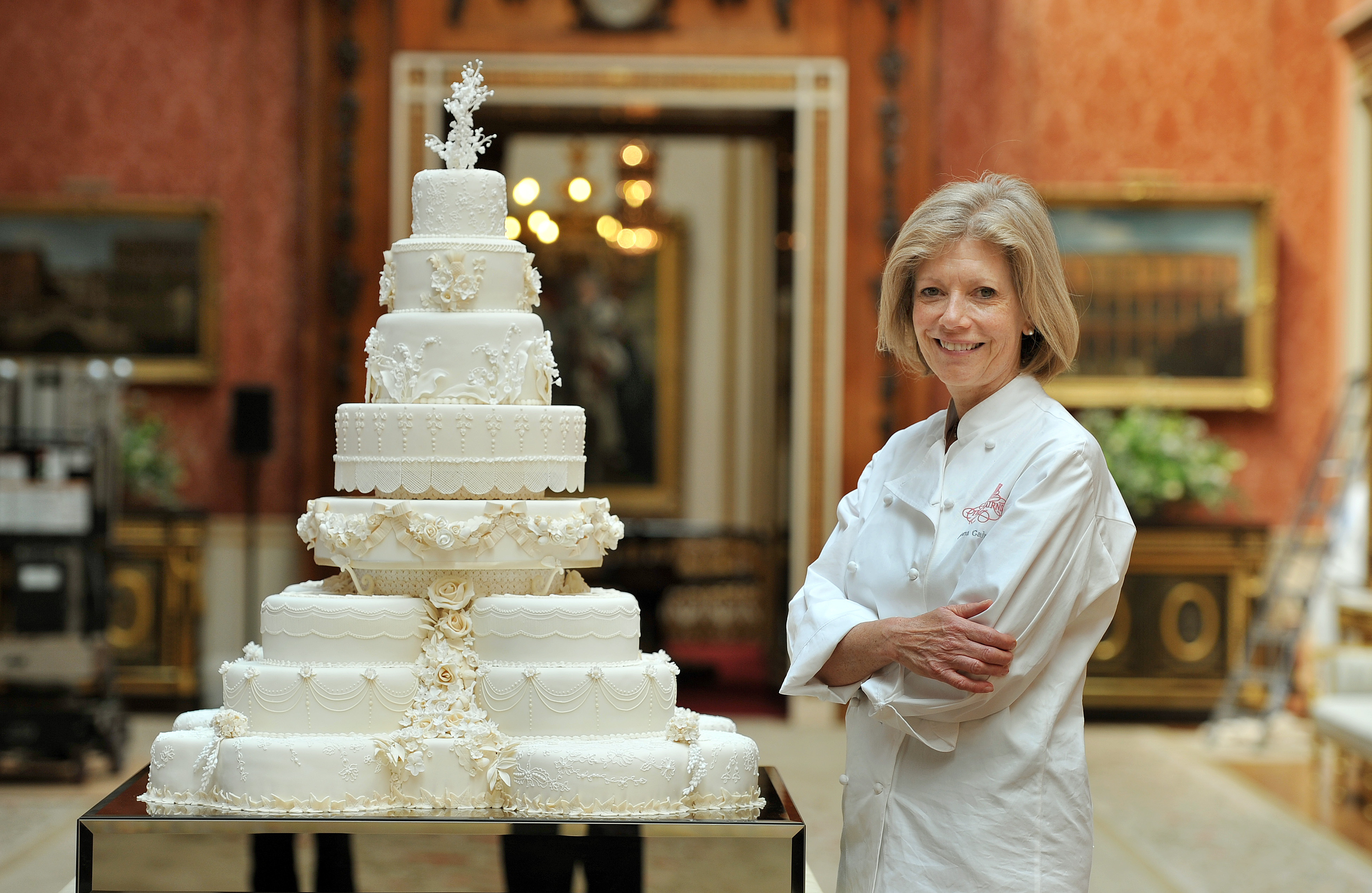 Fiona Cairns stands next to the Royal Wedding cake in Buckingham Palace in London on April, 29, 2011. (Photo credit should read JOHN STILLWELL/AFP via Getty Images)
